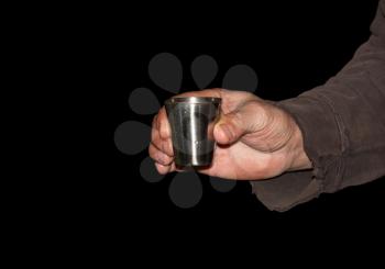 Wineglass in hand on a black background