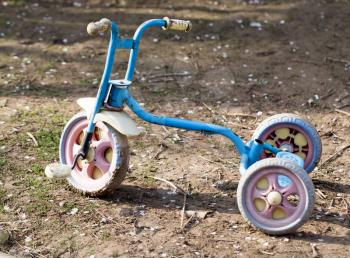 Old children's tricycle on nature