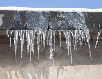icicles on a roof of a house in winter