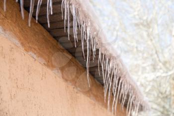 icicles on a roof of a house in winter