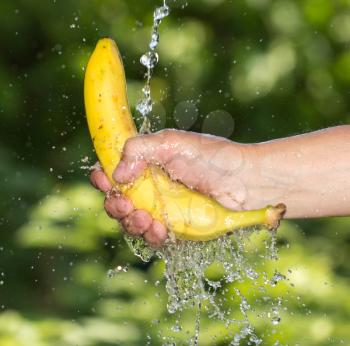 banana in his hand in a spray of water