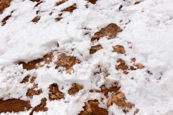 snow on red clay in nature