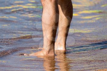 Men's legs on the beach