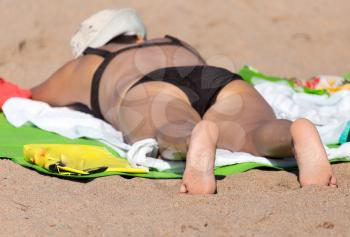 woman sunbathing on the sand on the beach