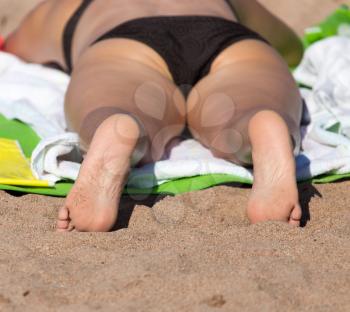 woman sunbathing on the sand on the beach