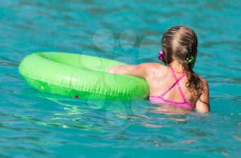 girl with a green balloon in the pool