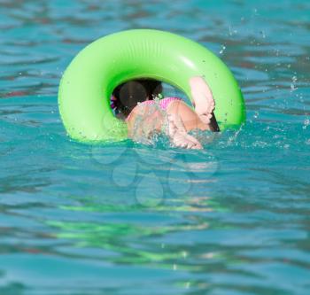 girl with a green balloon in the pool