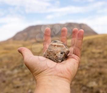 stone in hand on nature