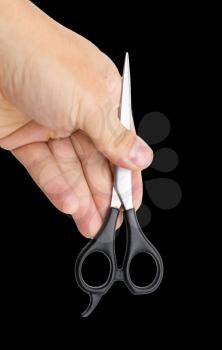 Scissors in hand on a black background