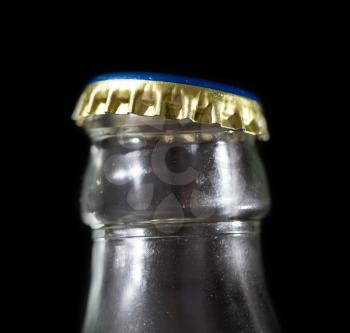 glass bottle neck with a cap on a black background
