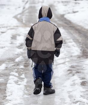 boy walking along the road in the winter