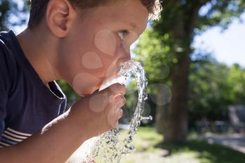 boy drinking water outdoors