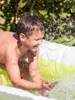 boy pours water from the pool in nature