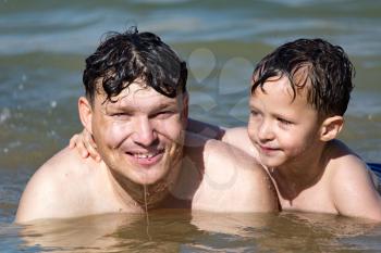 Dad and son swimming in the lake