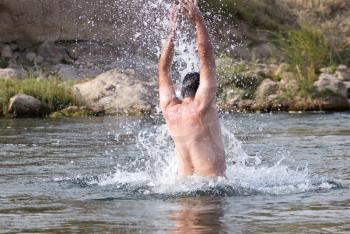a man jumps out of the water