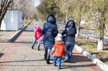 family with children walks in park