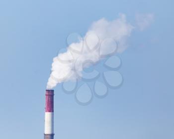 white industrial smoke from the chimney on a blue sky