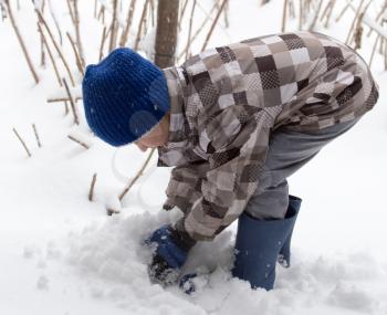Boy playing with snow in winter