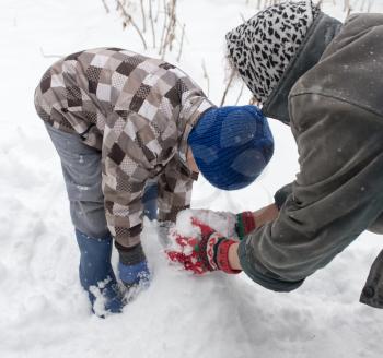 a boy with his grandmother playing in the snow