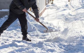 Worker cleans snow shovel