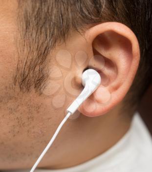 White earpiece in the ear of a man .