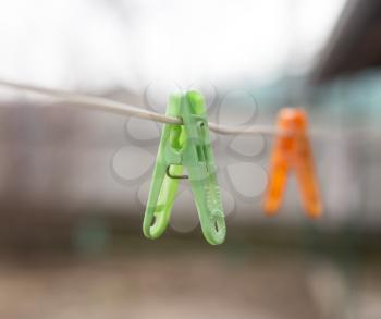 A Colorful clothespins on the clothesline outdoors .