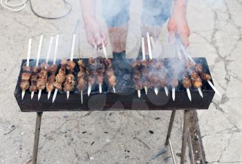 Cooking barbecue sticks on the grill in the open air