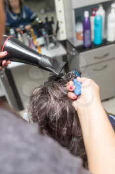 Styling female hair dryer in the beauty salon