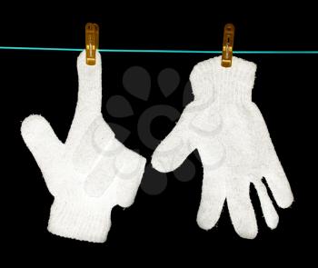 The glove is dried on a rope on a black background .