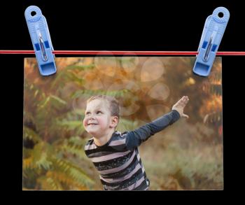 photo boy on a rope with clothespin on a black background .