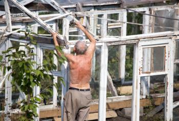 The old man works with a greenhouse in the country .
