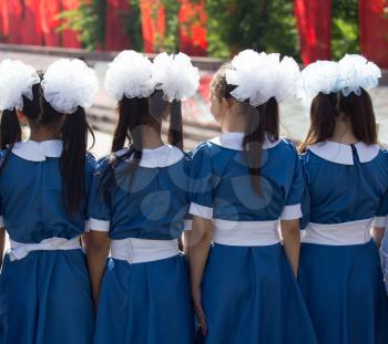 Choir of girls with white bows on head .