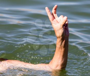 Man's hand on the water in the pool .