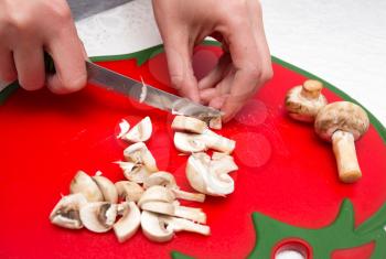 The cook cuts mushrooms with a knife .