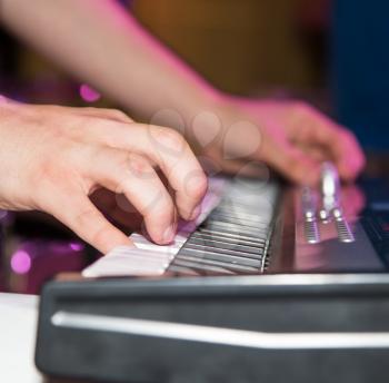 Musician plays keyboards in a rock band .
