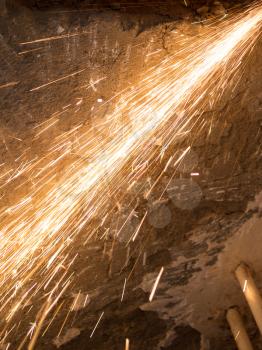 Worker cuts a metal pipe at a construction site .