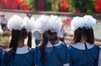 Choir of girls with white bows on head .