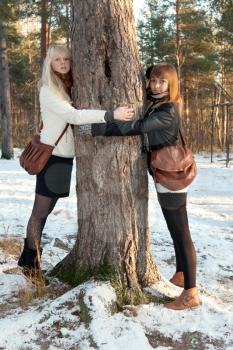 Royalty Free Photo of Two Women Hugging a Tree