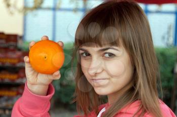 Royalty Free Photo of a Young Woman Holding an Orange