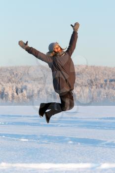 Royalty Free Photo of a Young Woman Jumping in the Snow