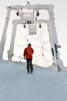 Royalty Free Photo of a Man Walking by a Ski Lift
