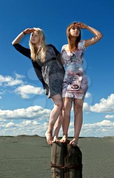 Royalty Free Photo of Two Girls Standing on a Post