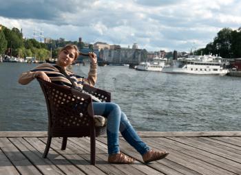 Royalty Free Photo of a Woman Sitting on a Pier