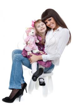Mother and daughter sitting on a chair in the studio on a white background