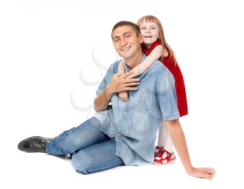 Smiling father and young daughter sitting on the floor. Isolated on white background