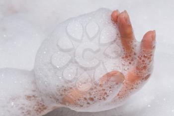 woman's hand in the foam in the bathtub