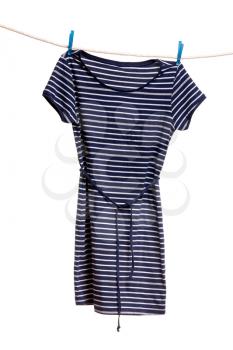 Women's striped dress hanging on a rope with clothespins. Isolate on white.