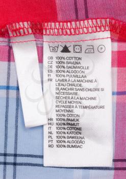 Close up view of a laundry advice clothing tag isolated on a checkered clothes