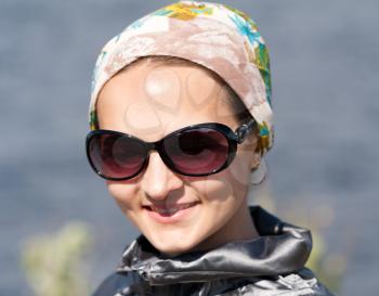 Close-up portrait of beautiful girl in the bandana and sunglasses