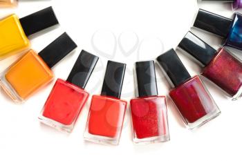 Coloured nail polish packed in a semicircle on a white background
